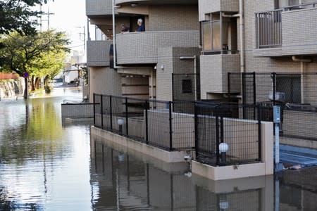 Residents look on from their home in a flooded residential area due to Typhoon Hagibis, in Kawasaki, Japan