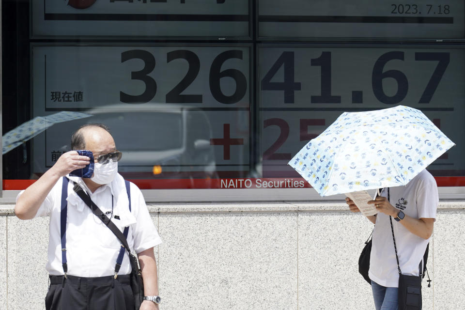 People stand in front of an electronic stock board showing Japan's Nikkei 225 index at a securities firm Tuesday, July 18, 2023, in Tokyo. Shares were mostly lower Tuesday in Asia as optimism over a Wall Street rally was countered by worries about the Chinese economy. (AP Photo/Eugene Hoshiko)