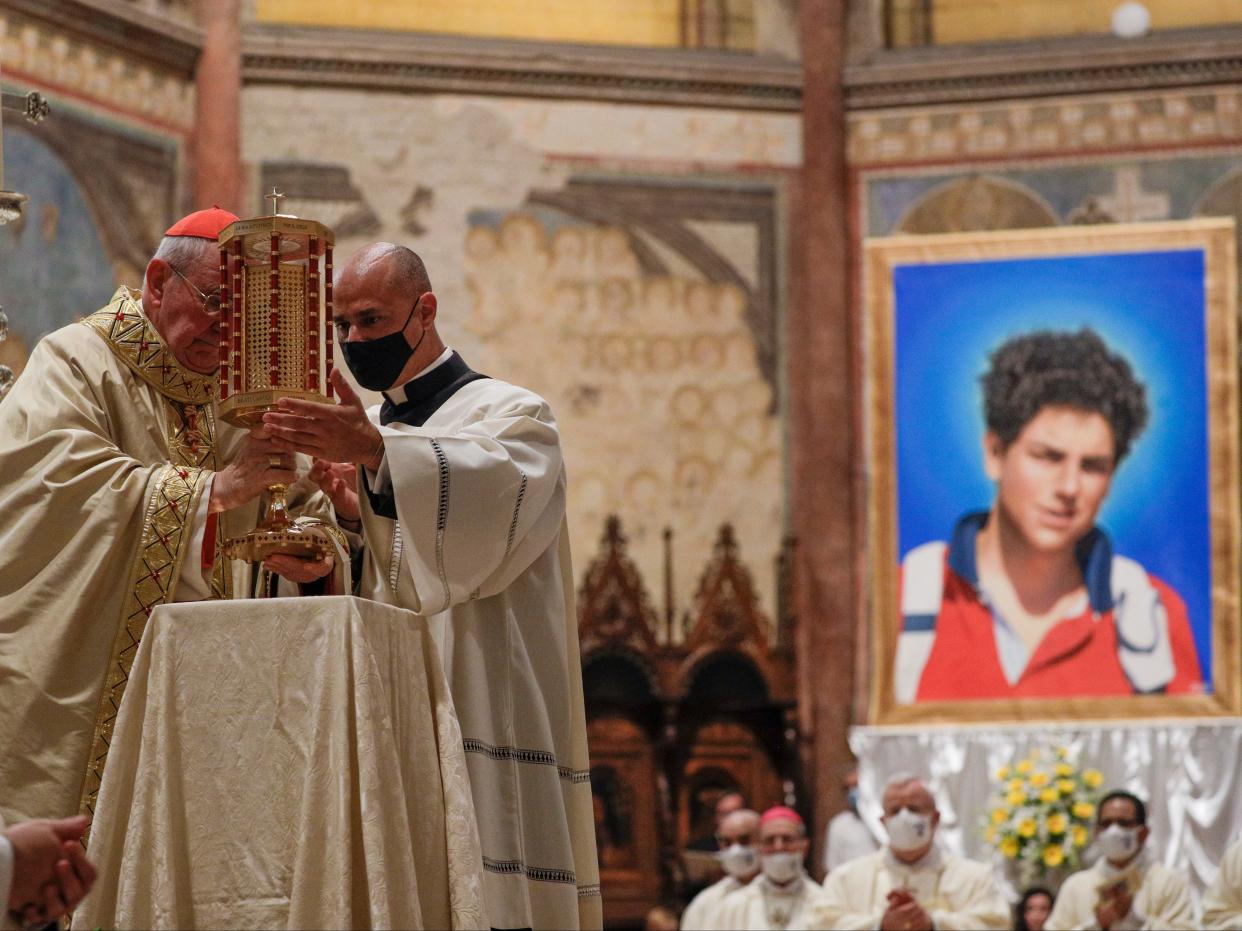 Cardinal Agostino Vallini (L) holds a relic of 15-year-old Carlo Acutis, who died in 2006 of leukaemia, during his beatification ceremony (AP)