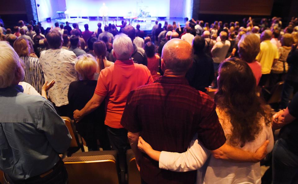 Cornerstone Church attendees pray during the first Sunday service after Thursday night's shooting left three people dead at the church parking lot in Ames, Iowa.