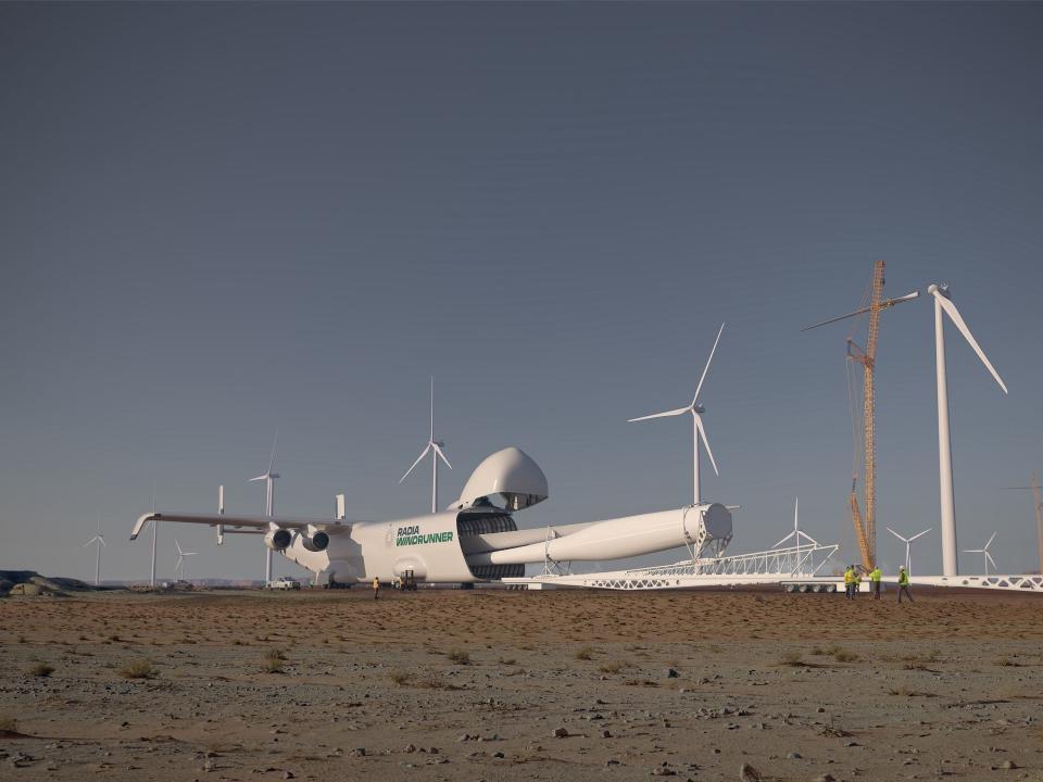 The Radia WindRunner in a field surrounded by wind turbines. It is unloading a giant turbine.