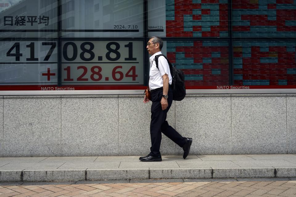 A person walks in front of an electronic stock board showing Japan's Nikkei index at a securities firm Wednesday, July 10, 2024, in Tokyo. (AP Photo/Eugene Hoshiko)