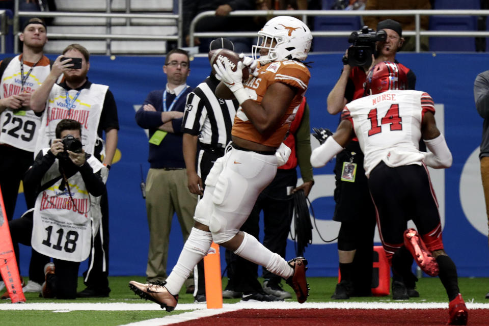 Texas running back Keaontay Ingram (26) catches a touchdown pass next to Utah defensive back Josh Nurse (14) during the second half of the Alamo Bowl NCAA college football game in San Antonio, Tuesday, Dec. 31, 2019. (AP Photo/Eric Gay)