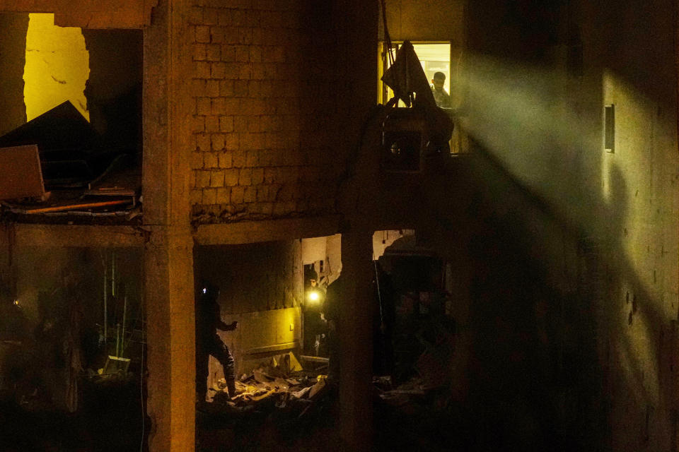 People search for survivors inside an apartment following a massive explosion in the southern suburb of Beirut, Lebanon, Tuesday, Jan. 2, 2024. (AP Photo/Hassan Ammar)