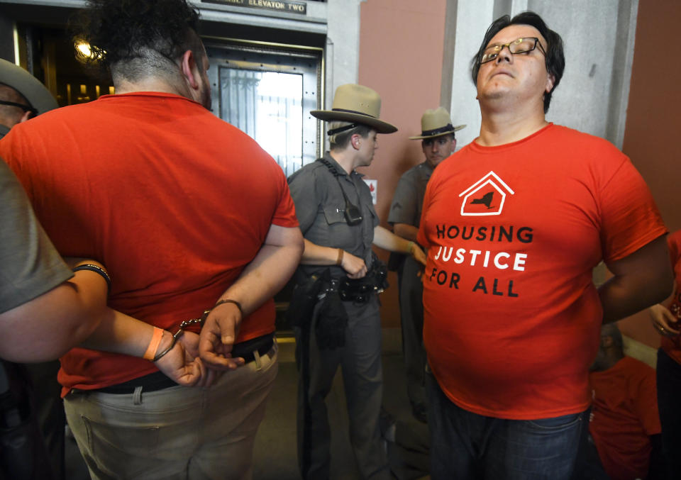 Protesters are arrested by state police as tenants and members of the Upstate Downstate Housing Alliance from across the state, demand New York Gov. Andrew Cuomo and state legislators pass universal rent control legislation that would strengthen and expand tenants rights across the state of New York before rent laws expire on June 15th during a protest rally at the state Capitol Tuesday, June 4, 2019, in Albany, N.Y. (AP Photo/Hans Pennink)
