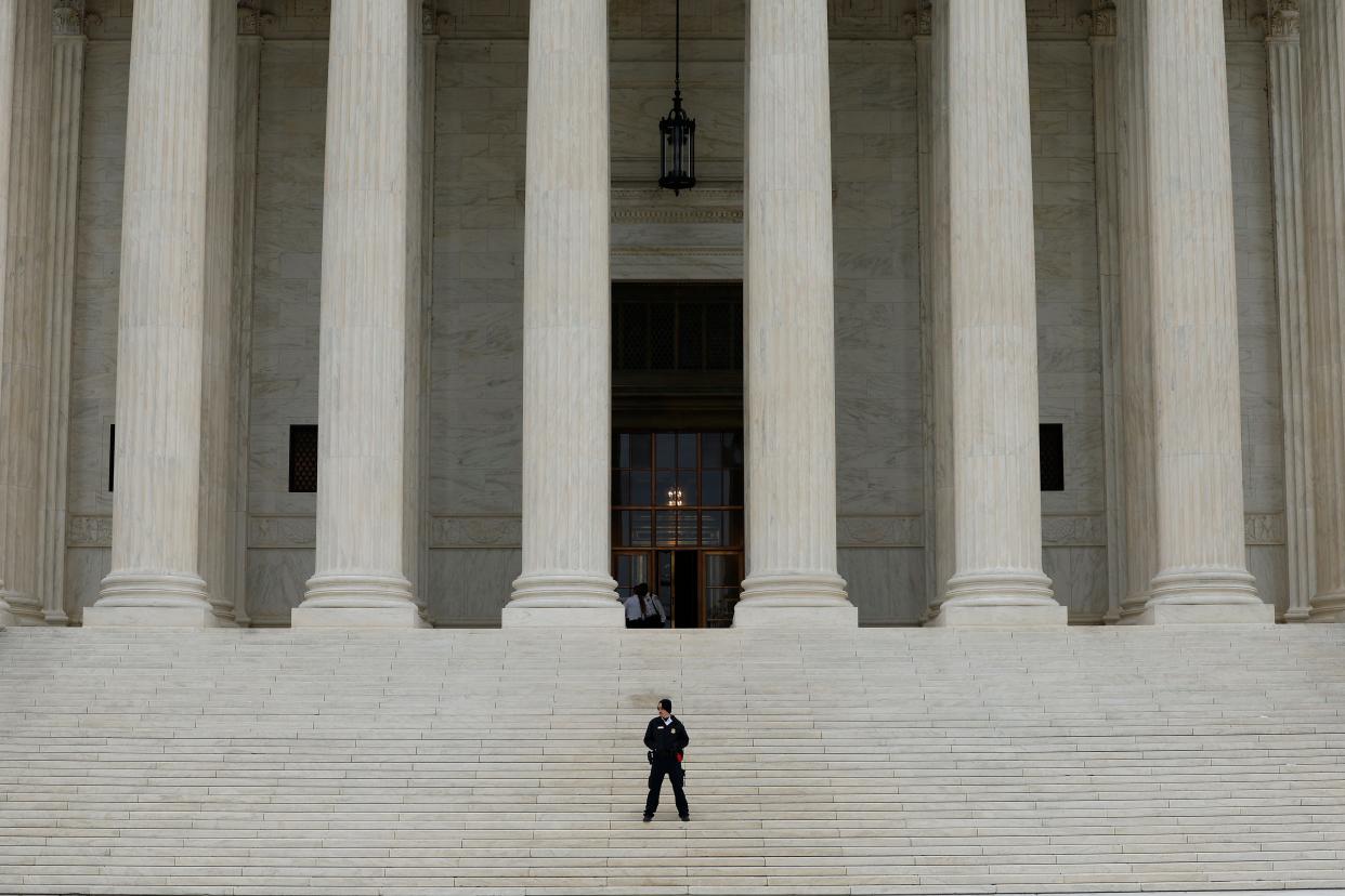 A law enforcement official stands on the steps of the U.S. Supreme Court Building on Oct. 03, 2022.