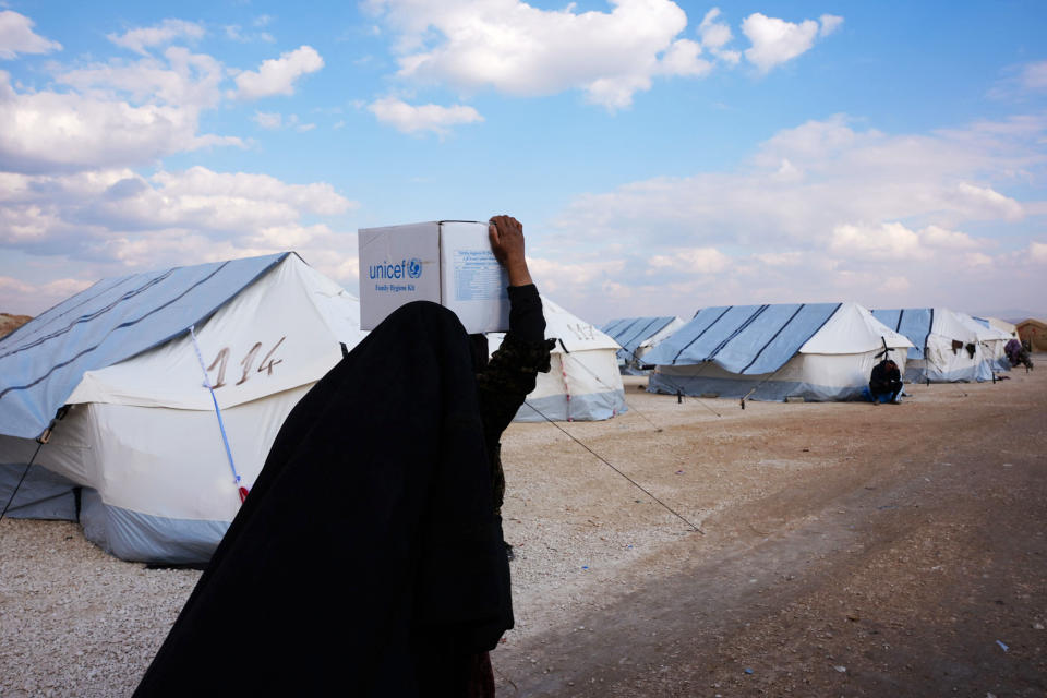 A Syrian woman carries a box of aid at a temporary camp in the village of al-Hamam in northwest Syria on Saturday.  (Rami Al Sayed / AFP - Getty Images)