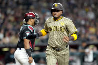 San Diego Padres' Luis Arraez scores on a base hit by Manny Machado during the first inning of a baseball game against the Arizona Diamondbacks, Saturday, May 4, 2024, in Phoenix. (AP Photo/Matt York)