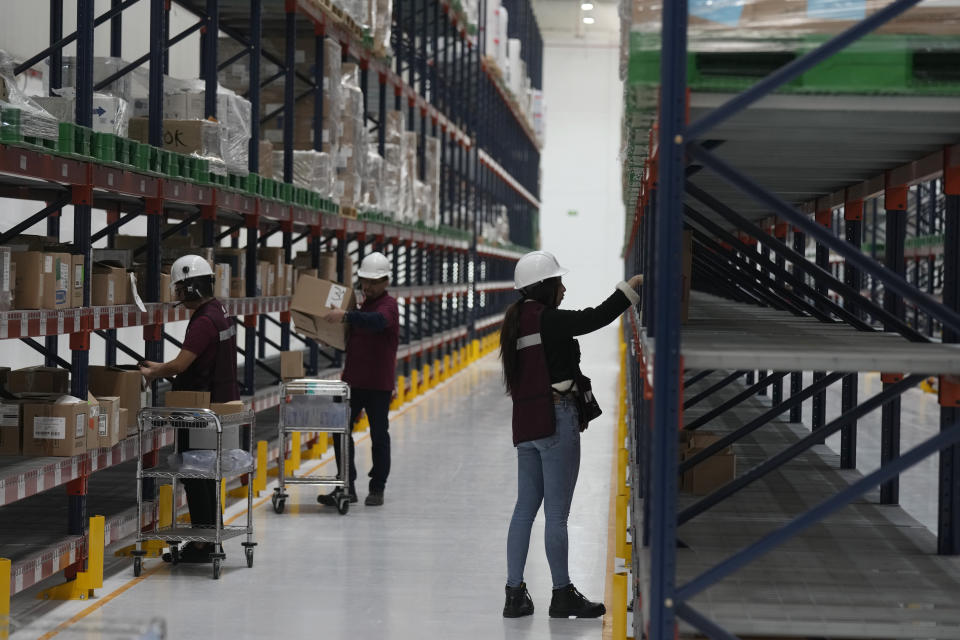 Workers unpack medicine at a "mega-pharmacy" warehouse on its inauguration day in Huehuetoca, Mexico, Friday, Dec. 29, 2023. It is Mexican President Andrés Manuel López Obrador's solution to help end a supply issue for hospitals that don't have specific medicines needed by patients. (AP Photo/Fernando Llano)