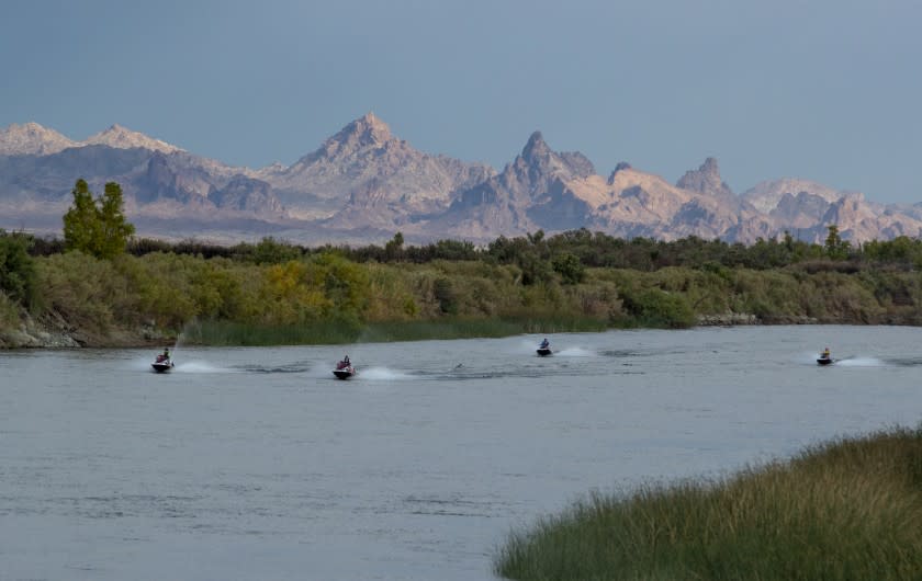 NEEDLES, CA - JUNE 23: Jet skiers power up the Colorado River against a backdrop of The Needles, a group of pinnacles in the Mohave Mountains, for which the Mojave desert town of Needles is named on Wednesday, June 23, 2021 in Needles, CA. (Brian van der Brug / Los Angeles Times)