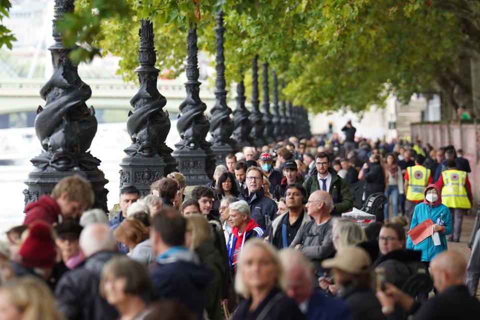 Personas formadas para despedirse de la reina Isabel II en el margen sur del río Támesis en Londres, el miércoles 14 de septiembre de 2022. Isabel II recibe honores de Estado de cuerpo presente en el Salón Westminster en el Palacio de Westminster en Londres. Los restos de la reina permanecerán en el salón hasta horas antes de su funeral de Estado el lunes. Se espera que acudan cientos de miles de personas a despedirse. (Stefan Rousseau/PA via AP)