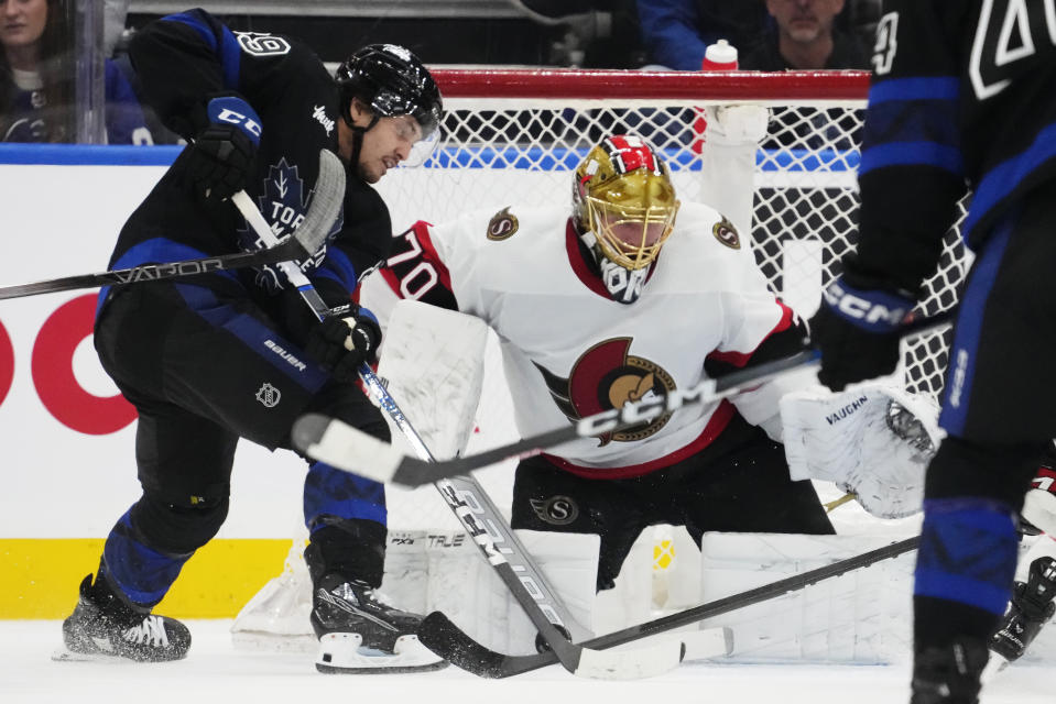 Ottawa Senators goaltender Joonas Korpisalo (70) makes a save on Toronto Maple Leafs' Nicholas Robertson (89) during the first period of an NHL hockey game, Wednesday, Dec. 27, 2023 in Toronto. (Frank Gunn/The Canadian Press via AP)