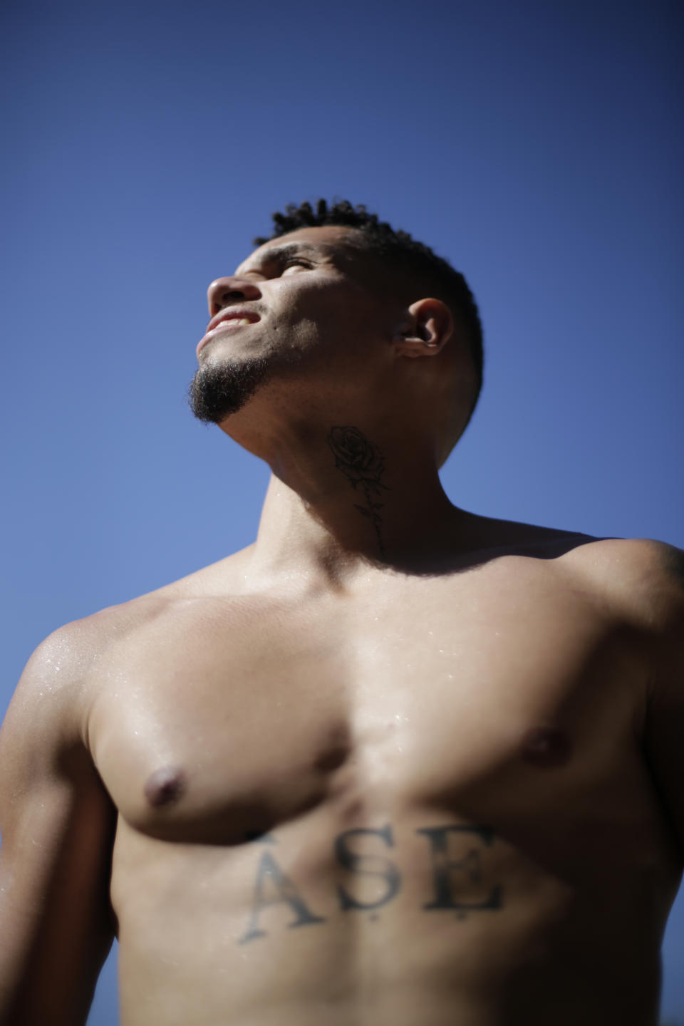 Paulinho of Brazil´s Atletico Mineiro poses for a photo showing his new tattoo that reads "Áse," or energy in the Yoruba language, which is key to the Candomblé religion, at his home in Belo Horizonte, Brazil, Sunday, Sept. 17, 2023. Paulinho showed his pride in Candomblé during a game after scoring a goal when he took off his shirt, displaying the tattoo for the first time. (AP Photos/Thomas Santos)