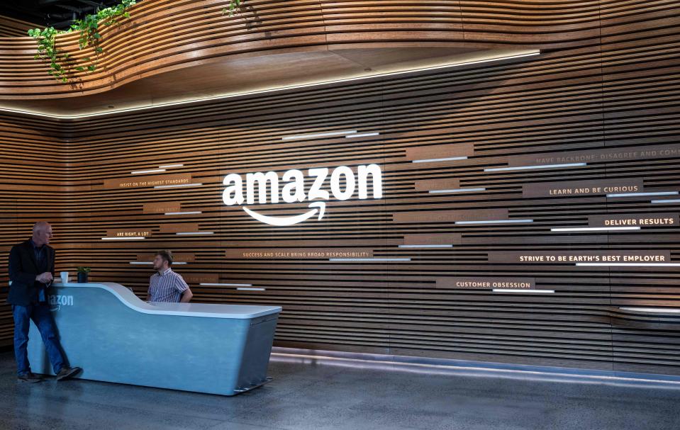 Two Amazon employees talk in September at one of the entrances to the new Amazon headquarters in Arlington, Virginia.