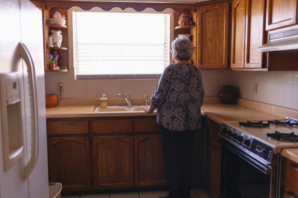 Woman in her kitchen stares out the window