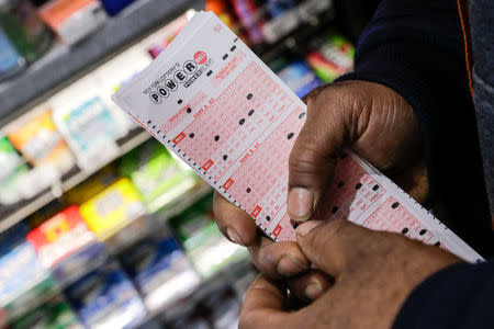 A customer buys tickets for the Powerball lottery in New York City, U.S., March 17, 2017. REUTERS/Jeenah Moon