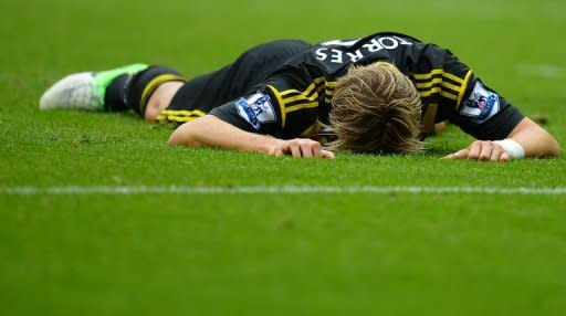 El delantero español del Chelsea Fernando Torres, tendido sobre el césped del estadio The DW tras haber fallado una ocasión en el partido de la liga inglesa contra el local Wigan este domingo 19 de agosto. (AFP | Andrew Yates)