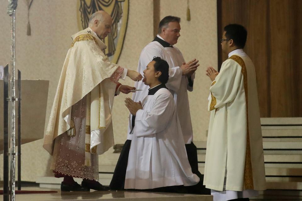 In this Sunday, April 12, 2020 file photo, San Francisco Archbishop Salvatore Cordileone, left, celebrates Communion during Easter Mass, which was live-streamed, at St. Mary's Cathedral in San Francisco.