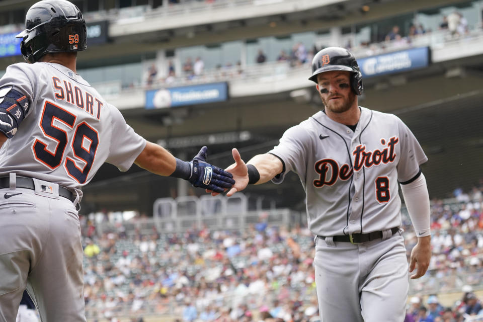 Detroit Tigers' Robbie Grossman (8) is greeted by Zack Short after Grossman scored on a two-run double by Jeimer Candelario off Minnesota Twins pitcher J.A. Happ in the fourth inning of a baseball game, Wednesday, July 28, 2021, in Minneapolis. (AP Photo/Jim Mone)