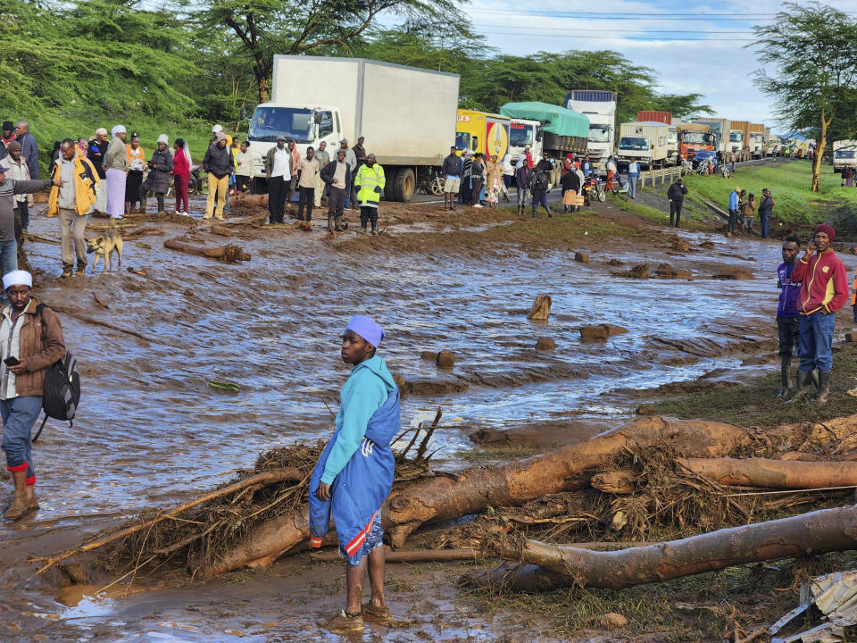 People gather on the main road after a dam burst, in Kamuchiri Village Mai Mahiu, Nakuru County, Kenya, Monday, April 29, 2024. Police in Kenya say at least 40 people have died after a dam collapsed in the country's west. (AP Photo)