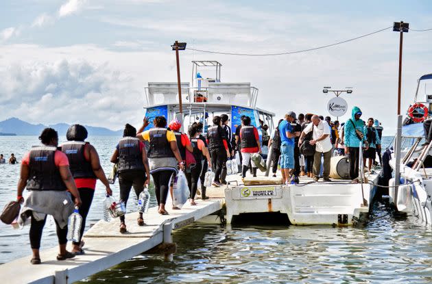 Stranded migrants, mostly from Venezuela, get on a boat in the Colombian port town of Necocli to cross into neighboring Panama to continue their journey to the United States on Oct. 11, 2022. (Photo: DANILO GOMEZ via Getty Images)