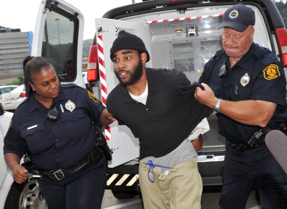 FILE - In this Sept. 21, 2012 photo, Klein Michael Thaxton, center, is lead into Pittsburgh Police headquarters after being apprehended without incident at Three Gateway Center in Pittsburgh, where held a businessman hostage inside the office building for more than five hours and posting Facebook updates during the standoff. Pittsburgh police plan to train their officers to be fluent in social media, joining other departments nationwide, days after the incident. (AP Photo/The Tribune-Review, JC Schisler, File) PITTSBURGH OUT