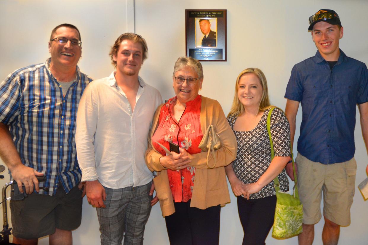 Brandy Winfield’s family smiles next to a plaque at the entrance to the Brandy Winfield OPOTA Classroom at the dedication.