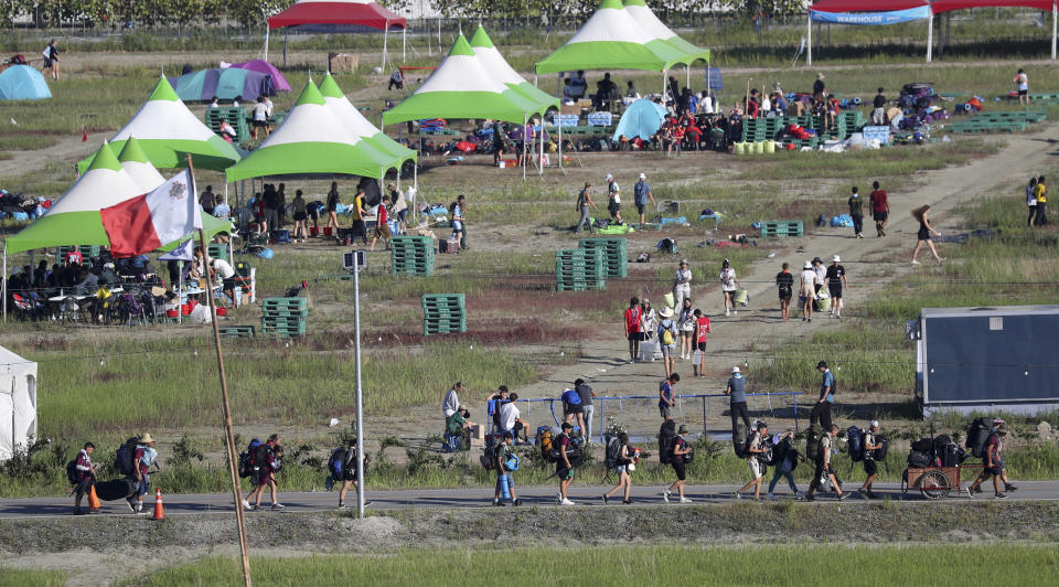 Attendees of the World Scout Jamboree move to leave a scout camping site in Buan, South Korea, Tuesday, Aug. 8, 2023. South Korea will evacuate tens of thousands of scouts by bus from a coastal jamboree site as Tropical Storm Khanun looms, officials said Monday. (Kim Myung-nyeon/Newsis via AP)