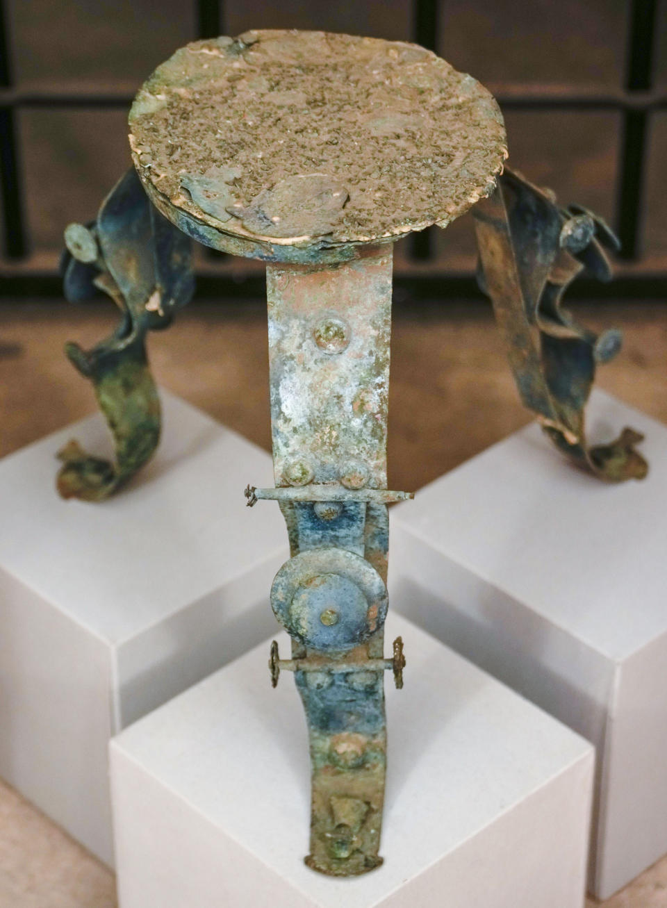 A rare and well-preserved tripod table in foil bronze, Etruscan production of the 7th century. B.C., most probably coming from an aristocratic sepulture and part of the 750 archaeological finds from clandestine excavations on Italian territory on display during a press conference in Rome, Wednesday, May 31, 2023. The set of artifacts, which can be dated overall between the eighth century BC. and the medieval period, and whose value is estimated at 12 million euros, was in possession of an English company in liquidation, Symes Ltd, attributable to Robin Symes, an important trafficker of cultural assets, and was repatriated from London on 19 May. (AP Photo/Domenico Stinellis)