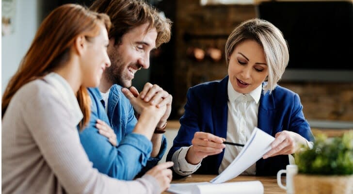 Young, happy couple with insurance agent