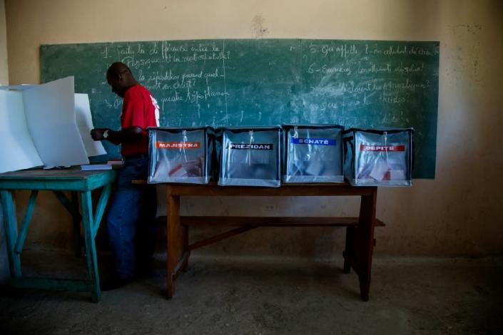 A voter casts his ballot at a polling station in the College Mixte des Cadres Evangeliques in Port-au-Prince on October 25, 2015 (AFP Photo/Michel Jean Pierre)