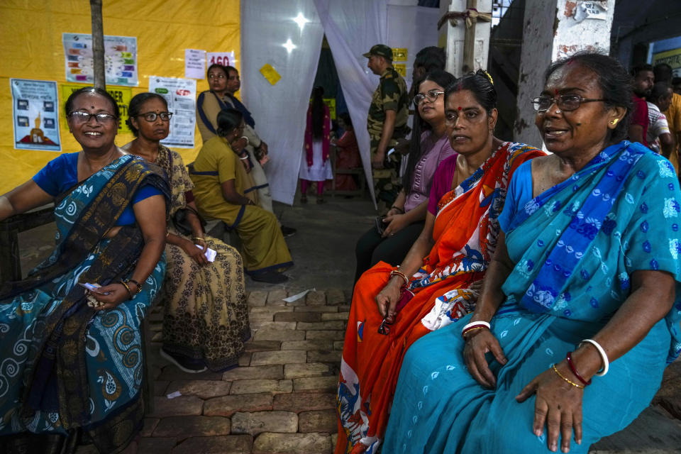 Voters wait outside a polling booth after the electronic voting machine (EVM) stopped working during the fifth round of multi-phase national election in Howrah, India, Monday, May 20, 2024. (AP Photo/Bikas Das)