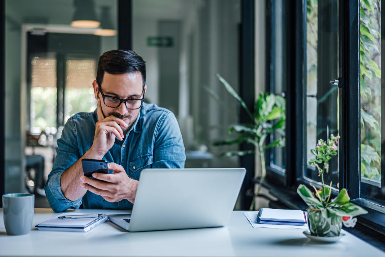 Smart adult man, working hard in the office, checking his notes.