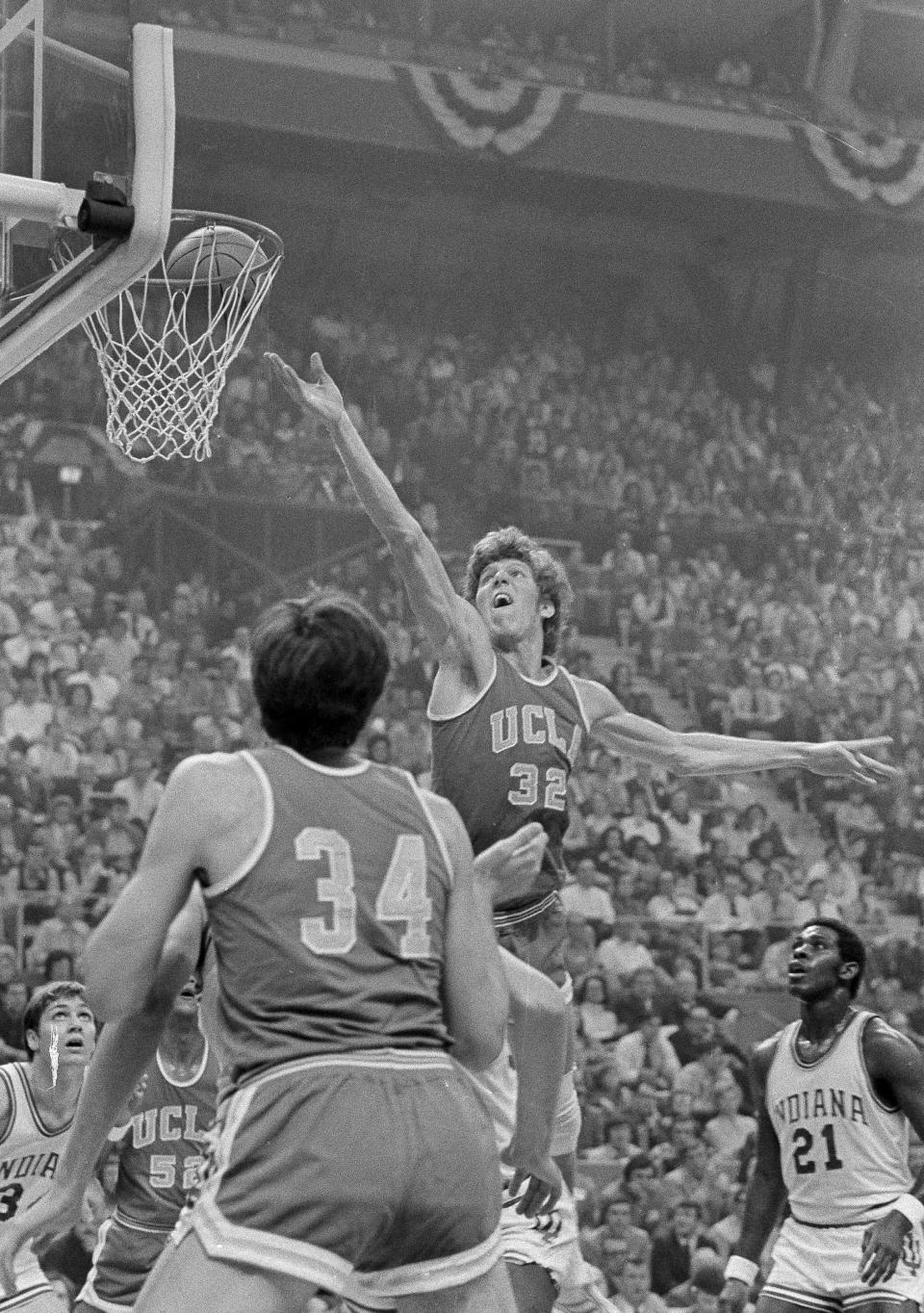 FILE - UCLA center Bill Walton goes to the basket against Indiana during the semifinal game of Final Four NCAA college basketball championship in St. Louis, March 24, 1973. At left foreground is UCLA's Dave Meyers, and Indiana center Steve Downing is at right. UCLA won, 70-59. (AP Photo/File)
