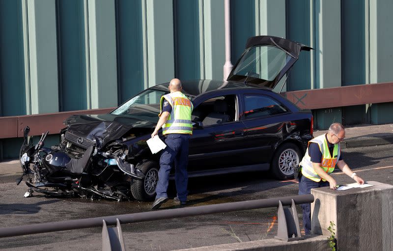 Police officers investigate the scene of a series of allegedly deliberate car crashes in Berlin