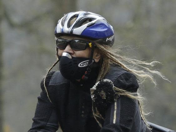 A cyclist wears an anti-air pollution mask