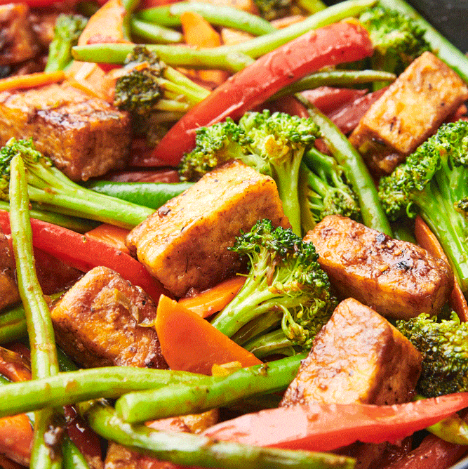 closeup of tofu stir fry with carrots, green beans, red peppers, and broccoli