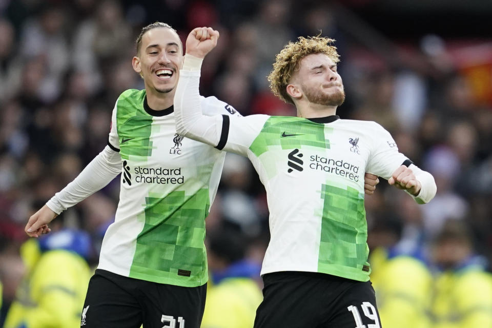 Liverpool's Harvey Elliott, right, celebrates with Liverpool's Kostas Tsimikas after scoring his side's third goal during the FA Cup quarterfinal soccer match between Manchester United and Liverpool at the Old Trafford stadium in Manchester, England, Sunday, March 17, 2024. (AP Photo/Dave Thompson)