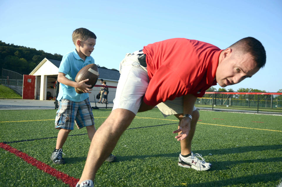 Kevin Lawrence hikes the ball to his son, Connor Lawrence, before a Susquehannock football game in 2012. A 6-year-old at the time, Connor is now a star sophomore baseball player at Red Lion High School.