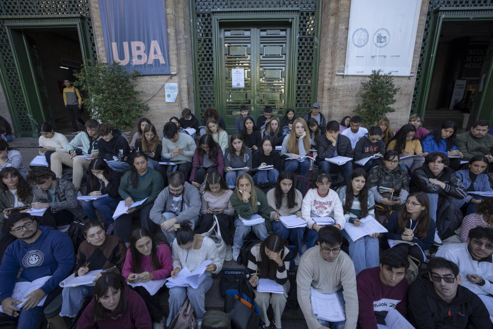 Estudiantes de la Universidad de Buenos Aires (UBA) toman clase en la calle en Buenos Aires, Argentina, el jueves 18 de abril de 2024. La UBA llevó al exterior las clases como protesta por el congelamiento de su presupuesto dispuesto por el presidente argentino, Javier Milei, como parte de sus medidas de austeridad. (AP Foto/Víctor R. Caivano)