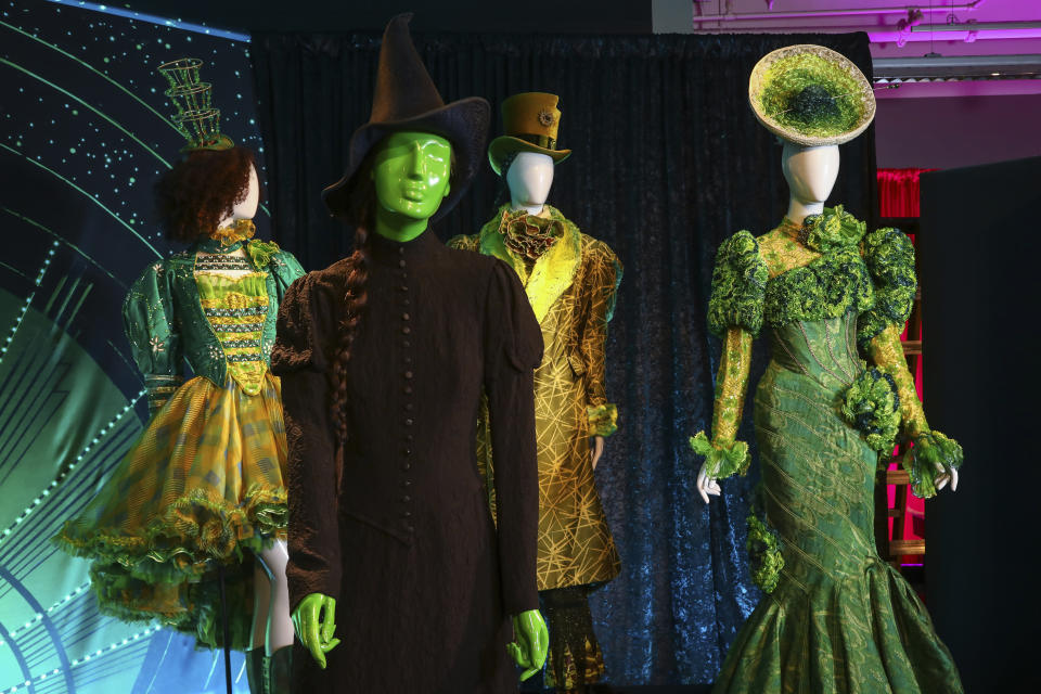 Prendas de vestuario del musical de Broadway "Wicked" se exponen como parte de "Showstoppers! Spectacular Costumes from Stage & Screen", una muestra a befenicio del fondo de recuperación de la Coalición del Instituto del Vestuario, el lunes 2 de agosto de 2021 en Times Square, en Nueva York. (Foto por Andy Kropa/Invision/AP)