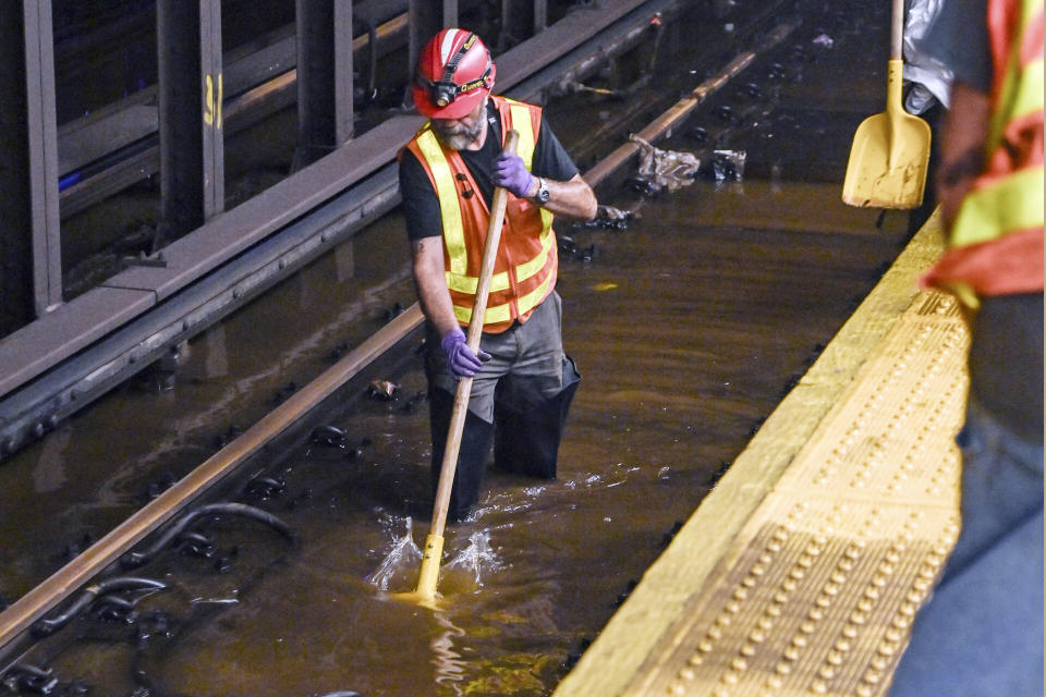 This photo, provided by MTA New York City Transit, shows an MTA worker knee-deep in water on subway tracks from a water main break in New York's Times Square, Tuesday, Aug. 29, 2023. A 127-year-old, 20-inch water main under New York's Times Square gave way early Tuesday, flooding midtown streets and the city's busiest subway station. (Marc A. Hermann / MTA, via AP)