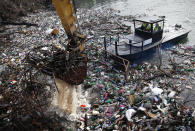 A crane clears tons of garbage stuck at the foot of the hydro power plant at the Potpecko accumulation lake near Priboj, in southwest Serbia, Friday, Jan. 22, 2021. Serbia and other Balkan nations are virtually drowning in communal waste after decades of neglect and lack of efficient waste-management policies in the countries aspiring to join the European Union. (AP Photo/Darko Vojinovic)