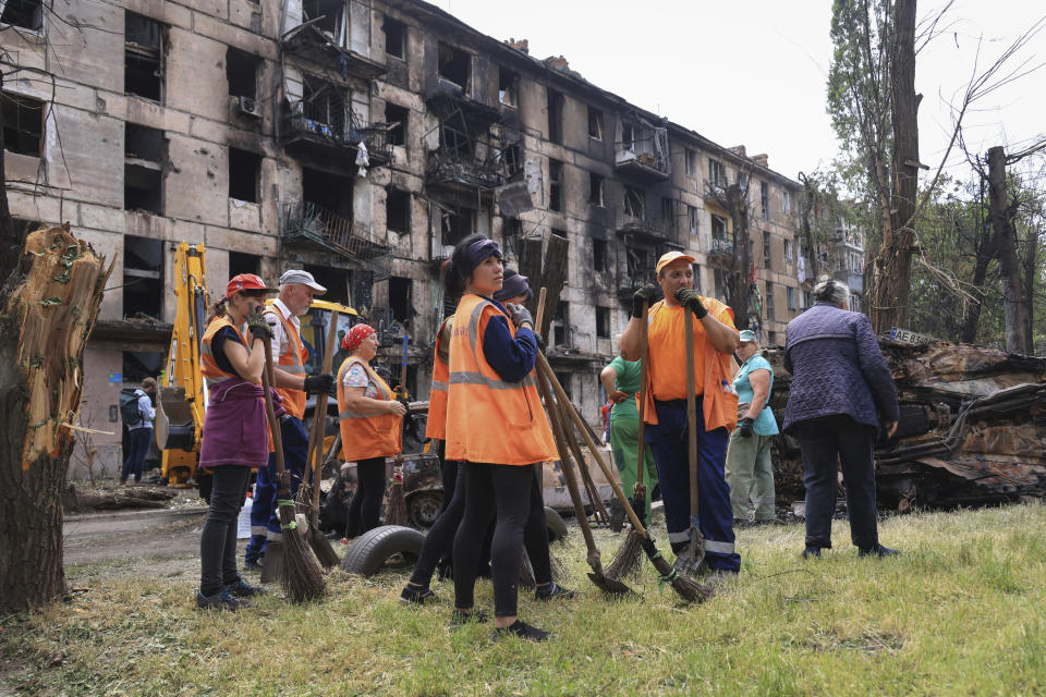 Municipal workers look at the scene of the latest Russian rocket attack that damaged a multi-storey apartment building in Kryvyi Rih, Ukraine, Tuesday, June 13, 2023. (AP Photo/Andriy Dubchak)