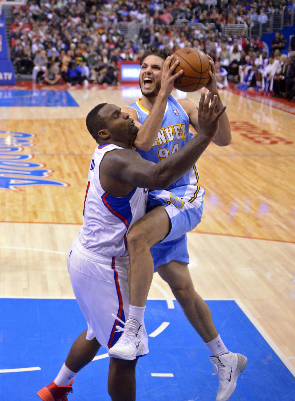 Denver Nuggets guard Evan Fournier, right, goes up for a shot as Los Angeles Clippers forward Glen Davis defends during the first half of an NBA basketball game, Tuesday, April 15, 2014, in Los Angeles. (AP Photo/Mark J. Terrill)