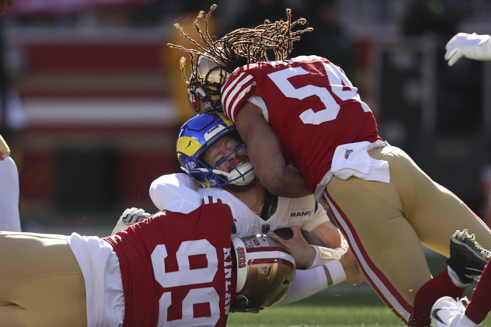 Los Angeles Rams quarterback Carson Wentz, middle, is tackled by San Francisco 49ers defensive tackle Javon Kinlaw (99) and linebacker Fred Warner (54) during the first half of an NFL football game in Santa Clara, Calif., Sunday, Jan. 7, 2024. (AP Photo/Jed Jacobsohn)