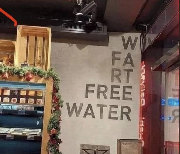 Sign reads "WATER FART FREE," due to incorrect line break, meant to say "FREE WATER."