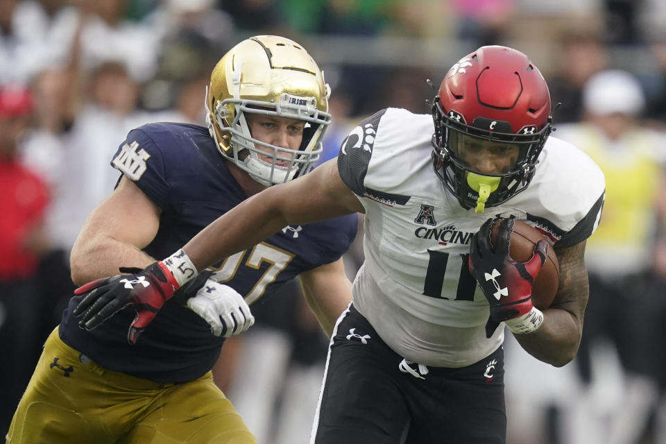 Cincinnati's Leonard Taylor (11) is chased by Notre Dame's JD Bertrand (27) during the second half of an NCAA college football game, Saturday, Oct. 2, 2021, in South Bend, Ind. Cincinnati won 24-13. (AP Photo/Darron Cummings)