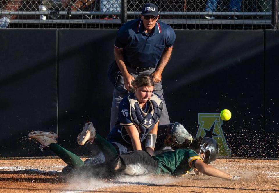 Bishop Carroll’s Allyson Orth beats the throw to home place and collides with Aquinas catcher Ella Przybylski in the first inning of their state championship game on Friday.