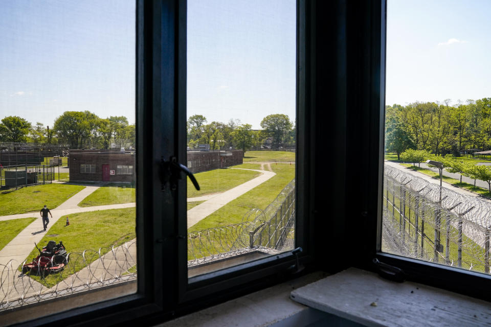 Jimmy Pilinci, studio and grounds manager, heads to his riding lawnmower as seen from the main guard tower at the former Arthur Kill Correctional Facility, Tuesday, May 11, 2021, in the Staten Island borough of New York. The facility was purchased by Broadway Stages in 2017 and has been transformed into a film and television studio. Much of the prison was preserved as a set, lending authenticity to scenes in productions. Five other sound stages are being built on the 69-acre site, giving production companies the ability to shoot entire projects. (AP Photo/John Minchillo)